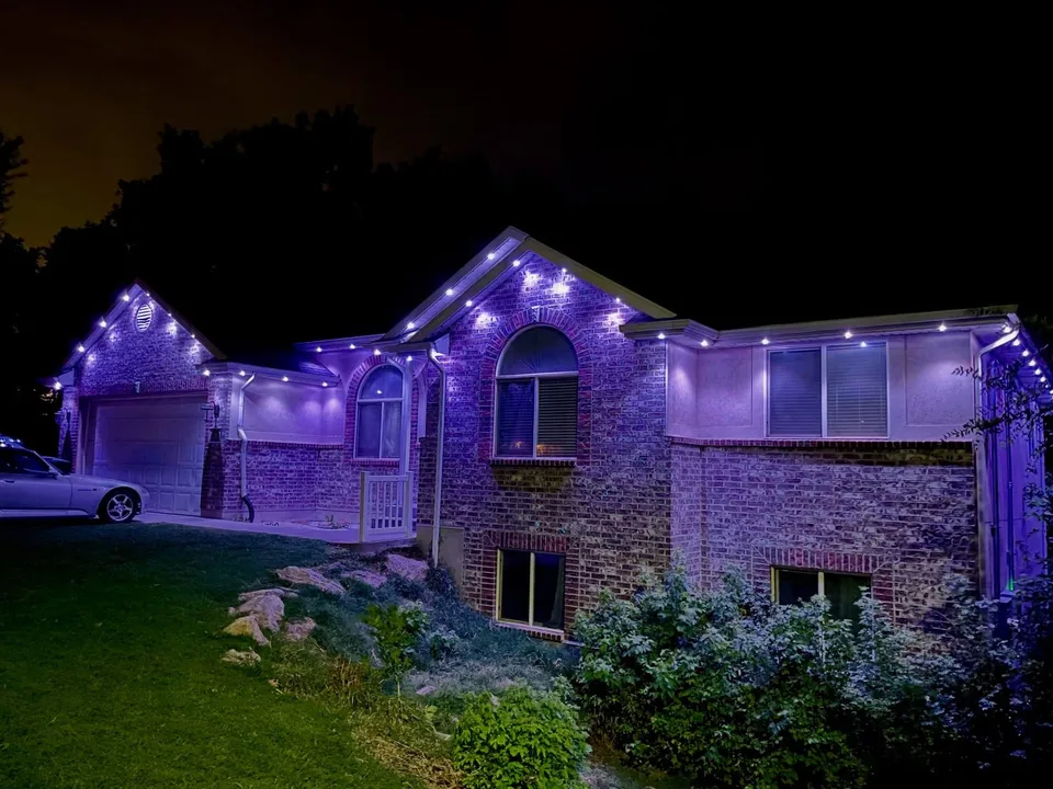 Brick home with purple permanent roofline lighting